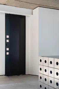A minimalist interior design featuring a modern metal dresser with circular cutouts.