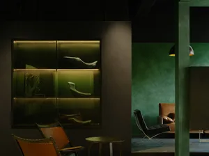 Modern lounge area featuring leather chairs, metal accents, and concrete walls.