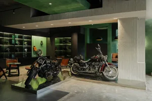 A sleek, modern interior space featuring a motorcycle exhibition with a concrete floor and minimalist design elements.