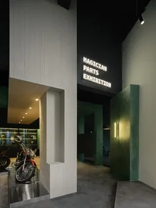 A motorcycle exhibition space featuring metallic, concrete, and wooden elements.
