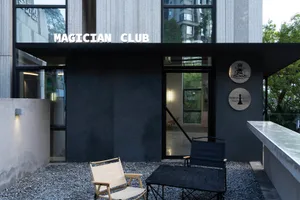 Outdoor seating area of a modern restaurant with concrete materials and minimalist design.