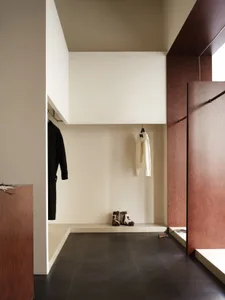 A minimalist wardrobe with wooden elements and a black floor.