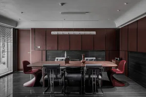 A modern dining room with wooden furniture, featuring a long wooden table surrounded by chairs of various styles.