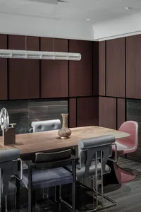 A modern dining room featuring wooden furniture including a rectangular table and various chairs around it.