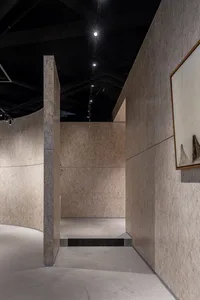 現代室內空間，牆面與天花板採用自然纖維板，並由天花板燈具照明。