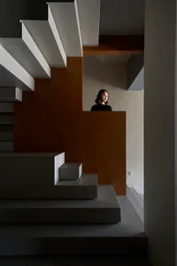 A modern interior with a concrete staircase and minimalist design.