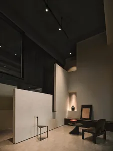 A minimalist concrete space featuring industrial-style furniture and modern design elements.
