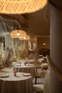 Well-lit restaurant interior featuring modern design with textured wood and concrete elements.