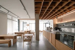 A modern coffee shop with wooden furniture and ceiling shelves.