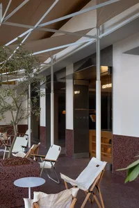 TerraCotta Cafe featuring a modern design with terrazzo flooring and white folding chairs.