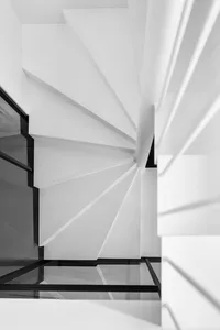 A minimalist staircase with concrete steps and a white wall.