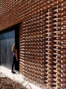 A modern architectural design featuring a textured brick wall with geometric patterns.
