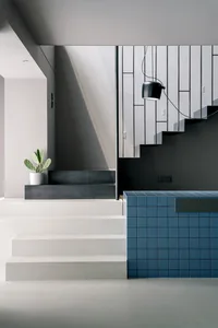 A modern interior space with concrete stairs and blue tiles.