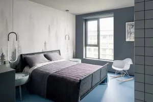 A modern minimalist bedroom featuring a rattan bed frame and minimalist decor.