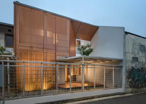 Modern house with wooden plank facade at dusk.
