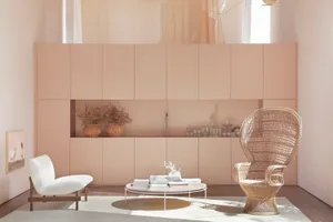 A modern living room with a minimalist design, featuring neutral-toned furniture and decor, and a central coffee table.