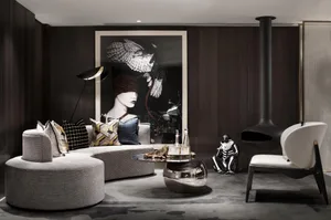 A modern living room featuring a round sofa with patterned pillows, a unique coffee table with a black fireplace and a black 