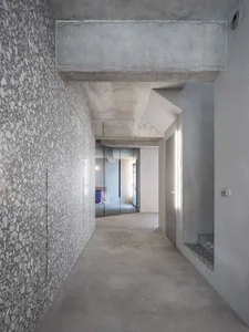 A modern apartment interior featuring concrete walls and flooring.