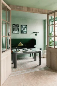 Modern living room interior with a marble tabletop desk, wooden dashboard, and concrete walls.