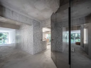 Modern kitchen with concrete walls and floor, featuring a textured surface and sleek design.