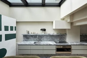 Modern kitchen with marble countertops and grey stone backsplash