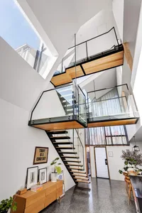 Modern home interior featuring a floating staircase with wood and glass materials.