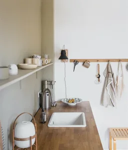 A minimalist residential kitchen featuring marble countertops and wooden kitchen island.
