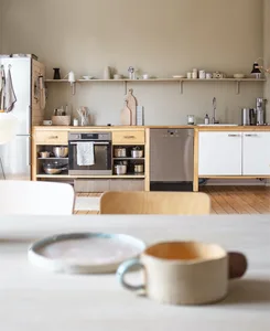 Minimalist industrial kitchen designed with wooden cabinets, exposed metal elements, and clean lines.
