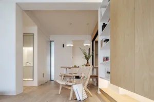 A modern minimalist dining room featuring wood and concrete materials.