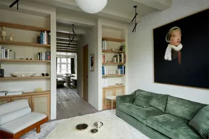 A modern living room with wooden furniture and a green sofa.