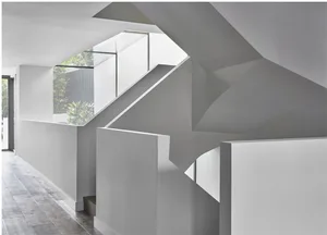 A modern minimalist staircase with white concrete walls and steps.