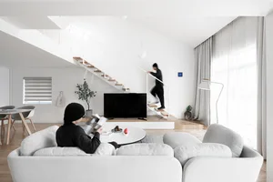 A modern minimalist living room featuring neutral tones and a clean, uncluttered design.