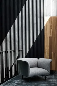 Modern office waiting area featuring wood paneling, metal railings, and upholstered seating.