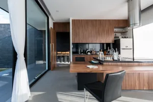 A modern residential kitchen featuring wooden furniture and cabinets.