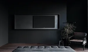 A minimalist bedroom with a dark color palette, featuring a bed with textured bedding, a wall-mounted flat-screen TV, and a s