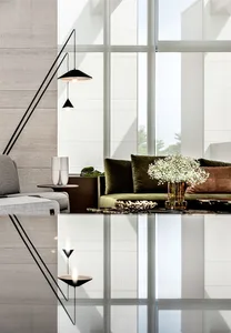 A modern living room with concrete walls, glass windows, and a glass coffee table.