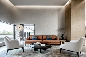 Modern living room with brown sofa, white chairs, and a black coffee table, featuring a large window with a view of the outdo