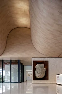 Modern lobby area with marble walls and a metal sculpture
