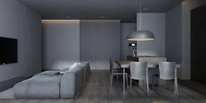 A minimalist living room with concrete walls, a grey sectional sofa, and a dining table with grey chairs.