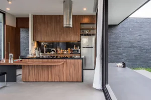 Modern residential kitchen with wooden cabinetry and stainless steel appliances.