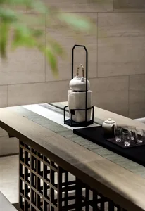 A modern tea room featuring a ceramic teapot on a wooden table with a green and white runner.