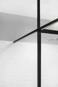 Modern minimalist bathroom featuring black metal frame, black glass shower enclosure, and white tiles.