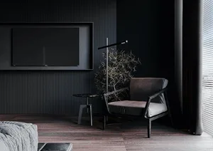 A modern, minimalist living room featuring dark walls, a grey sofa, a black armchair, and a black floor lamp.