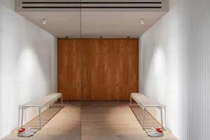 A modern entrance featuring a wooden door and benches.