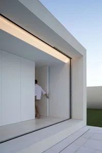 A modern architectural design featuring large glass panels and a minimalistic interior.