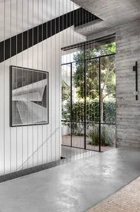Modern, industrial-style interior with concrete walls and large window.