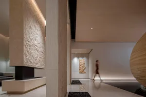 A modern lobby interior featuring a combination of tile, concrete, and molded wood materials.