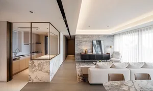 Modern minimalist living room featuring a white marble floor, white sofa, and black and white abstract art.