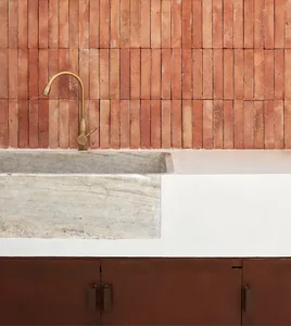 Minimalist kitchen with industrial-style metal faucet and concrete stone sink