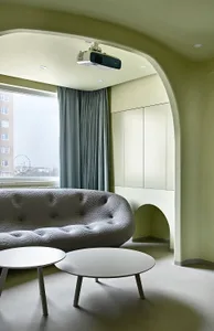A minimalist living room with a concrete sofa and tables.